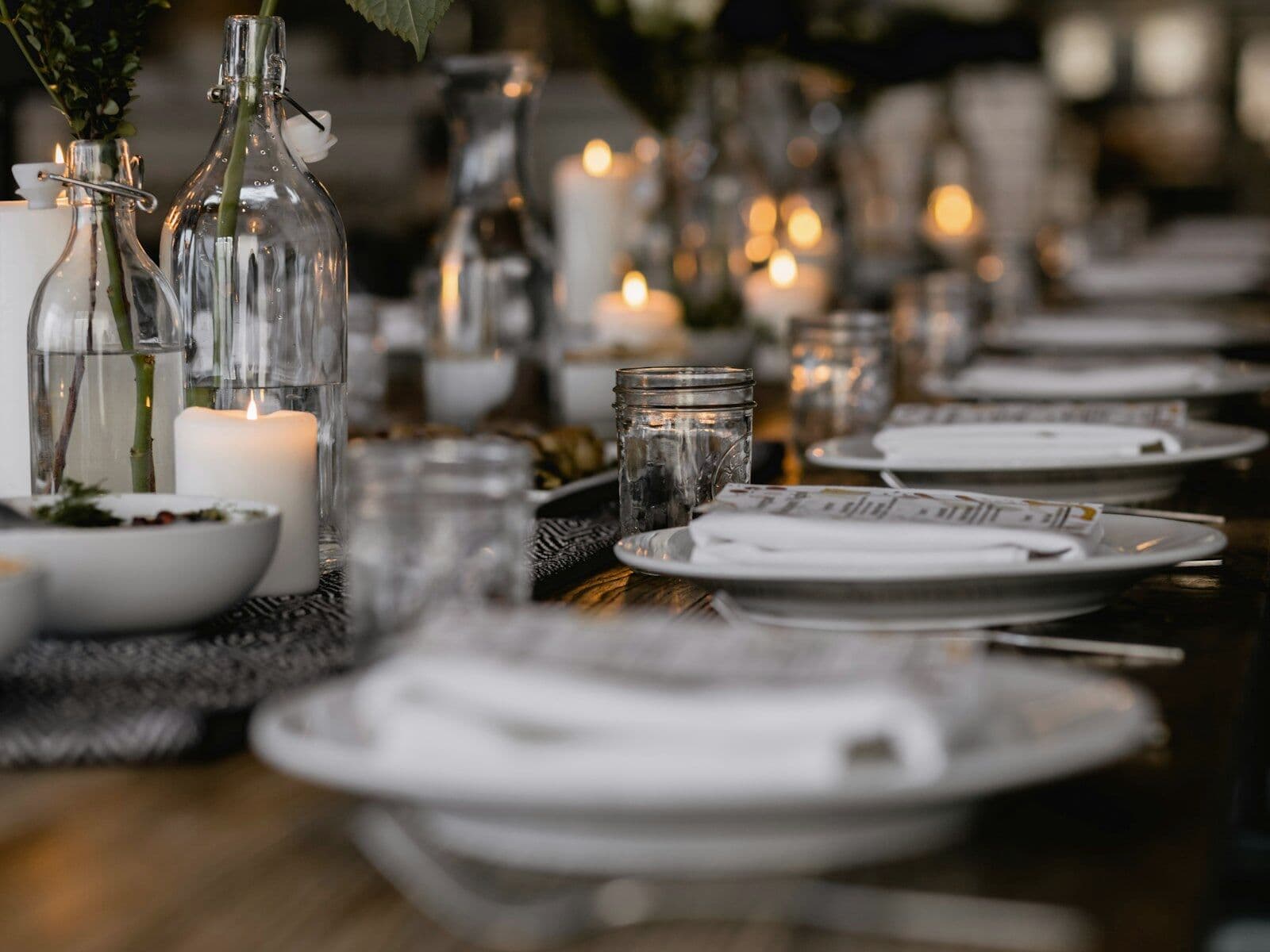 A candlelit dinner table with place settings