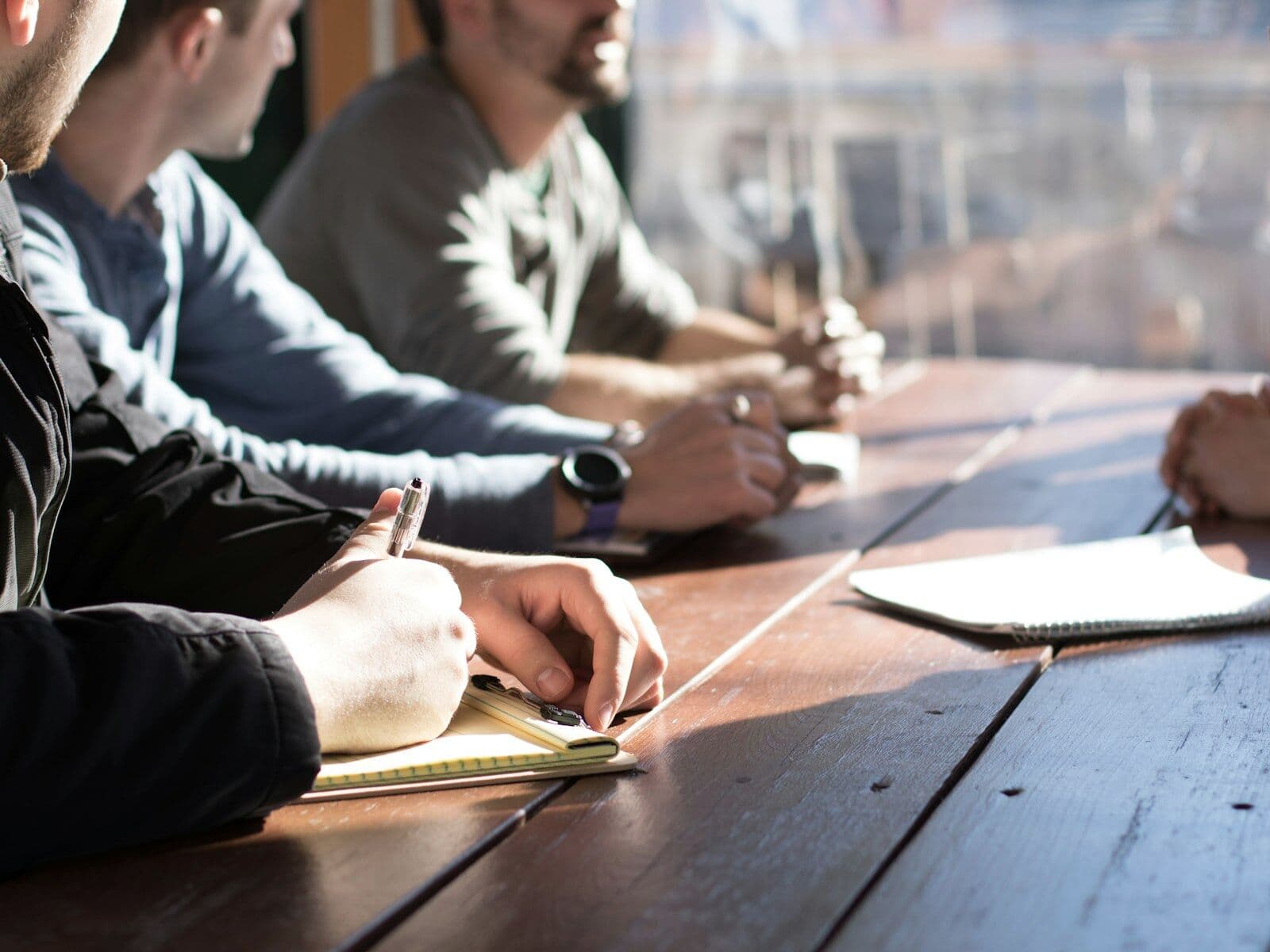 Owners working side by side at a long table with notebooks open